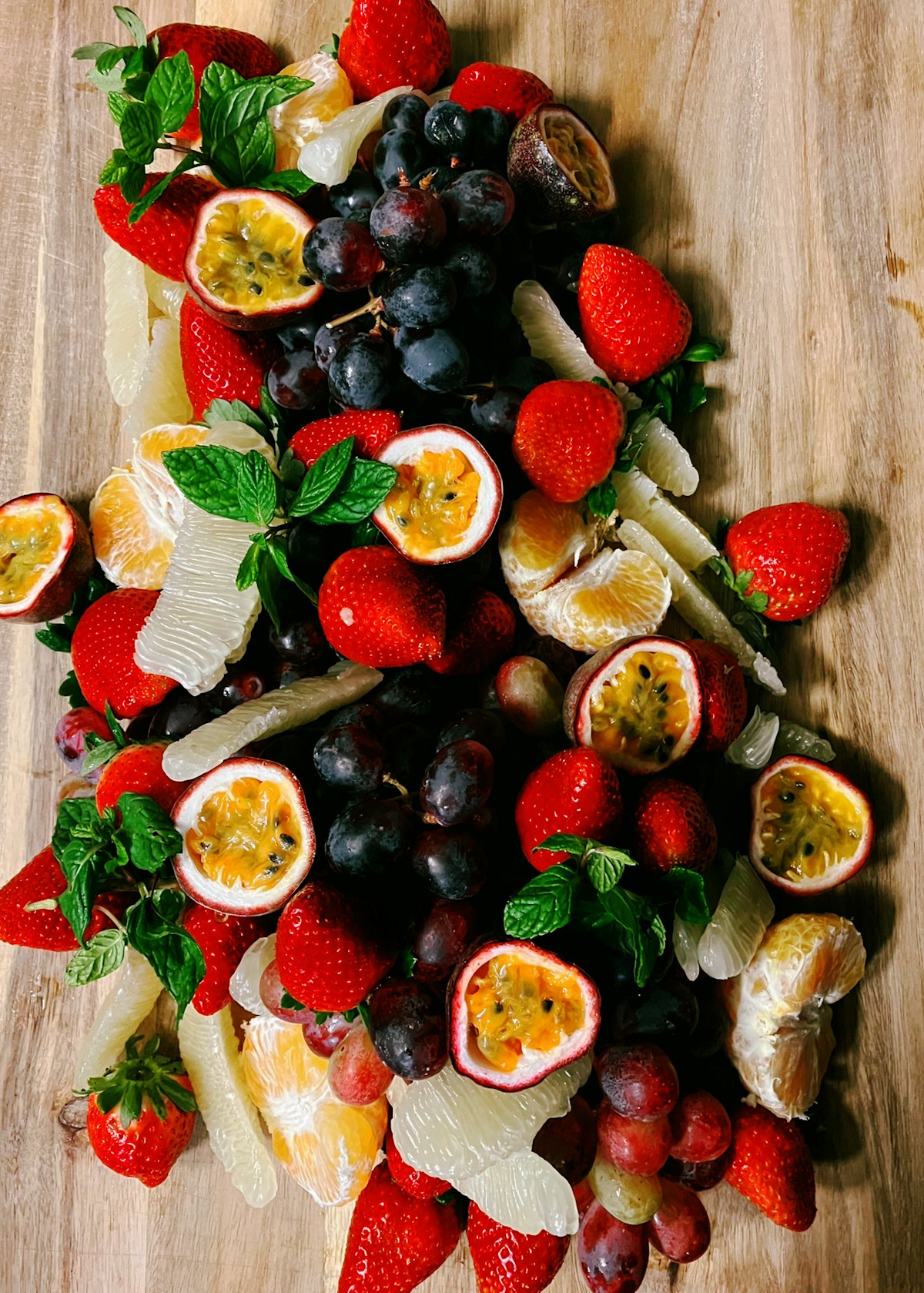 Plateau de fruits frais : fraises, raisins, agrumes et fruits de la passion