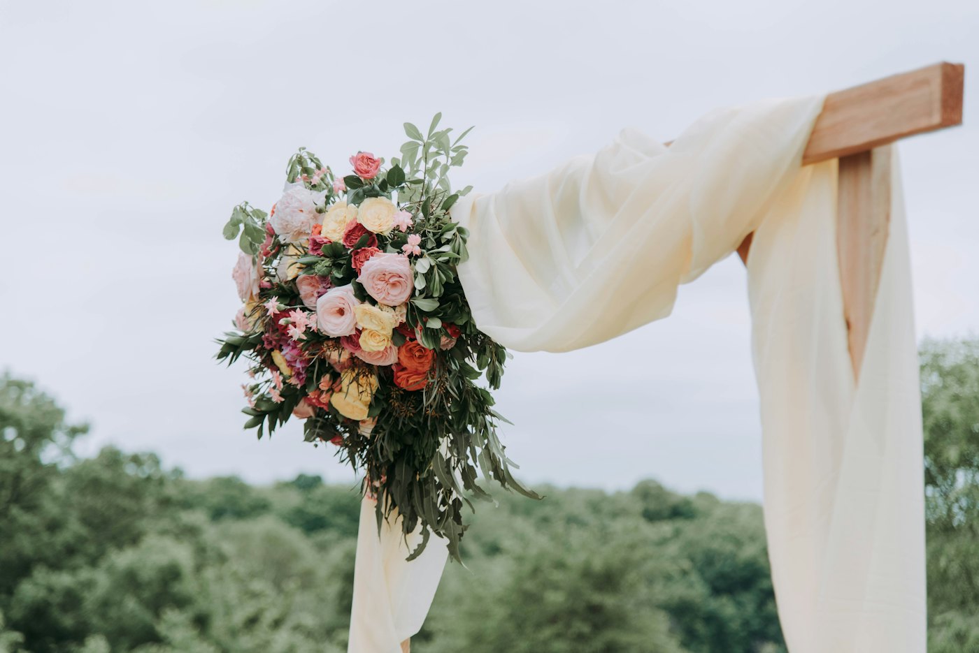 Arche drapée de tissu blanc et de fleurs roses
