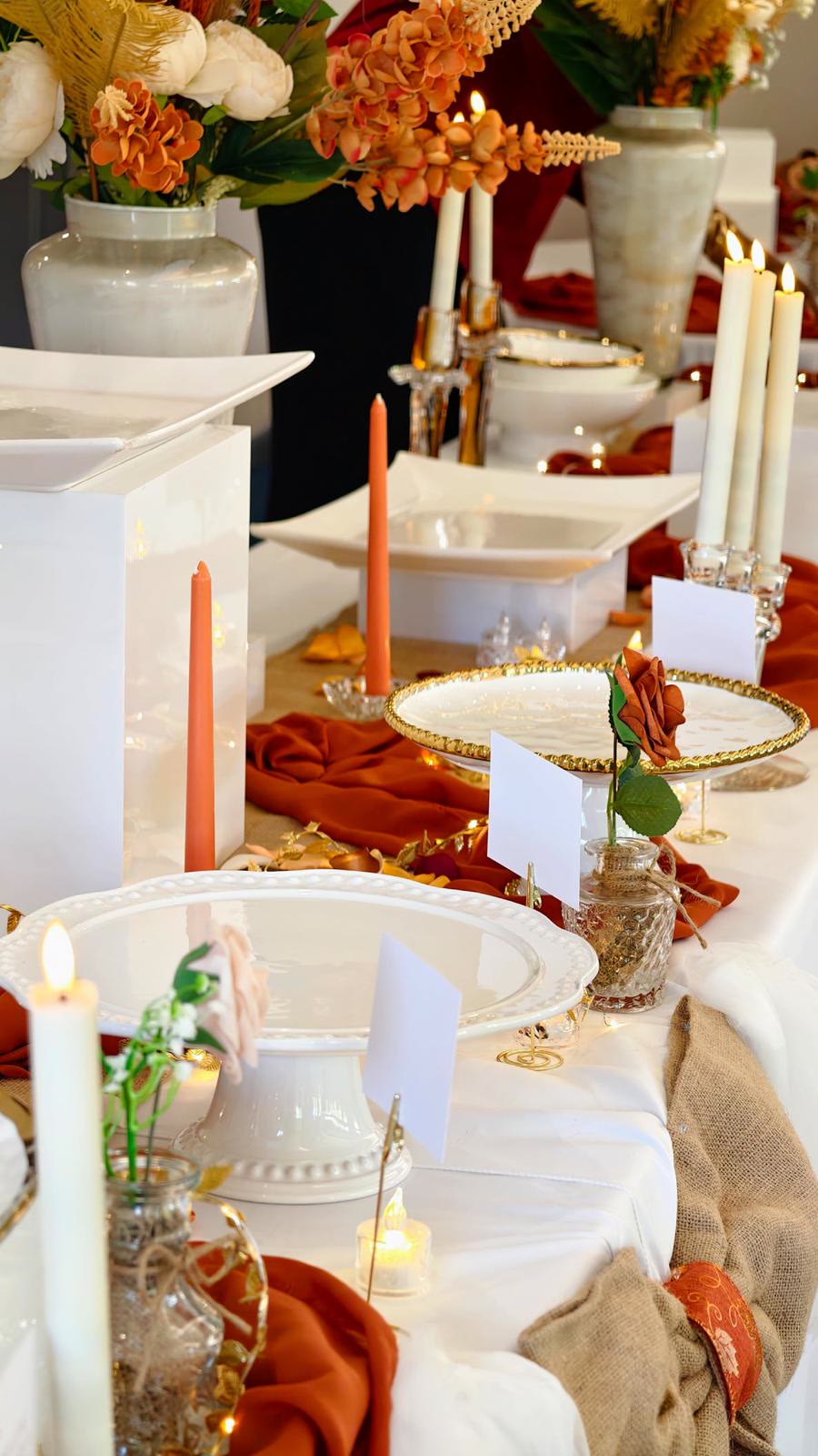 Table de réception terracotta et blanc avec bougies, présentoirs et roses